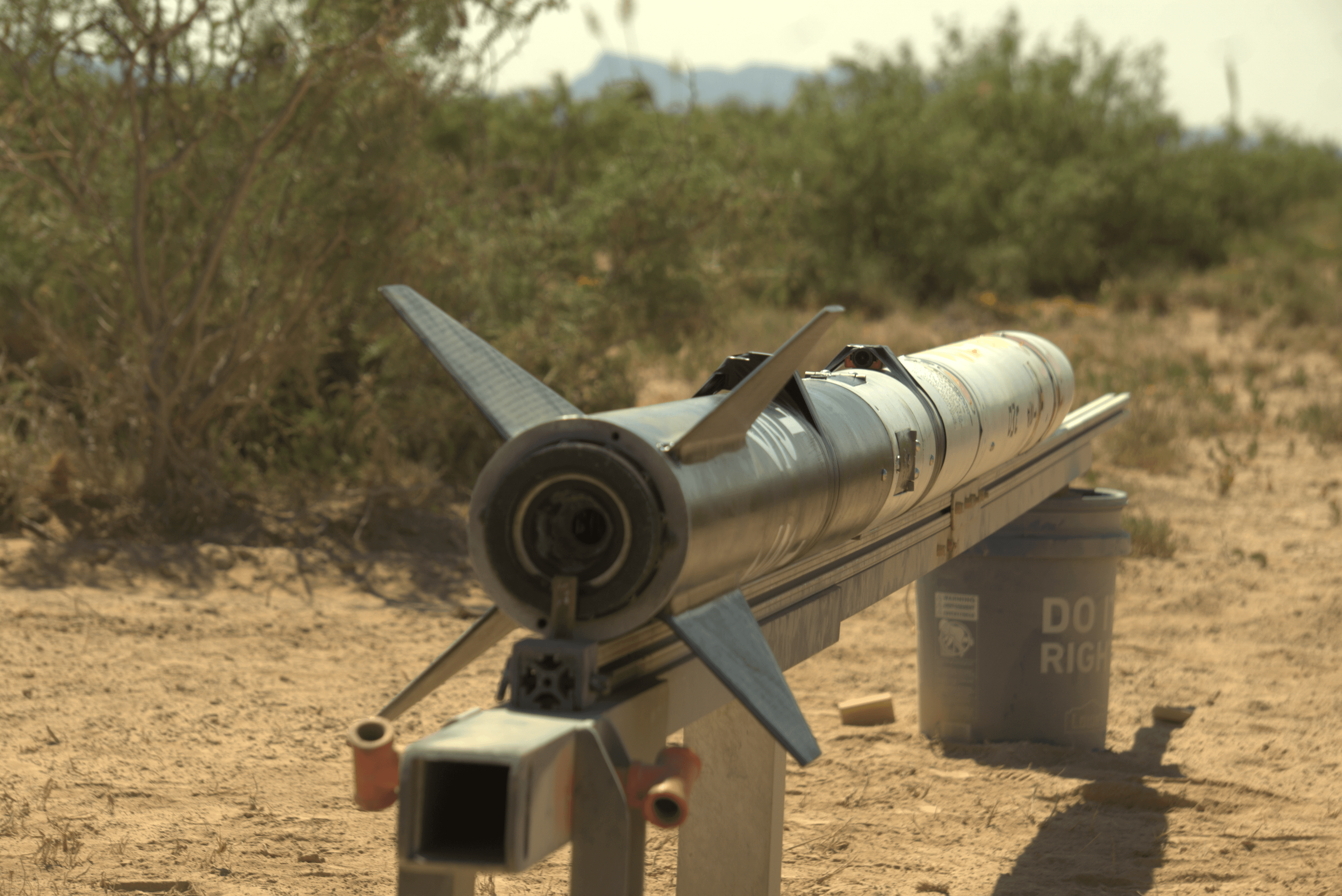 The complete rocket in the desert mounted to the launch rail, still laying horizontally